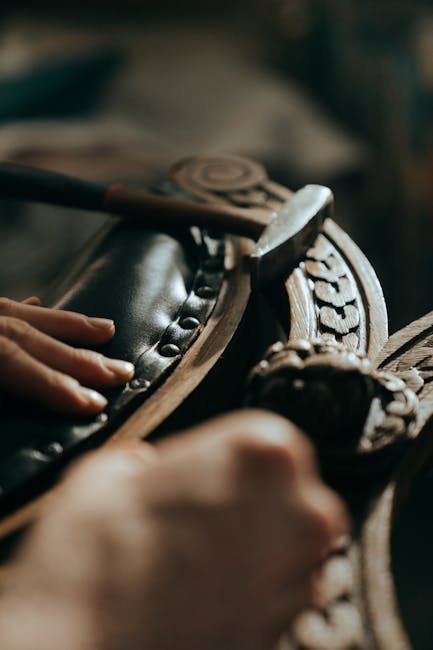 Close-up of skilled hands restoring antique wooden furniture with intricate carvings.